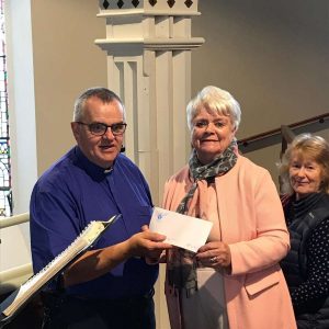 Anna Monahan presents Fr. Tom Ryan with a cheque for €1000.00 for the painting of the cathedral from Ennis Cathedral choir